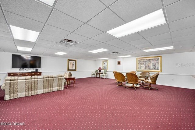 miscellaneous room with a paneled ceiling and carpet flooring