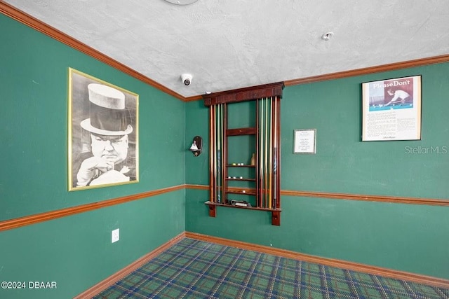 empty room featuring a textured ceiling, carpet floors, and crown molding