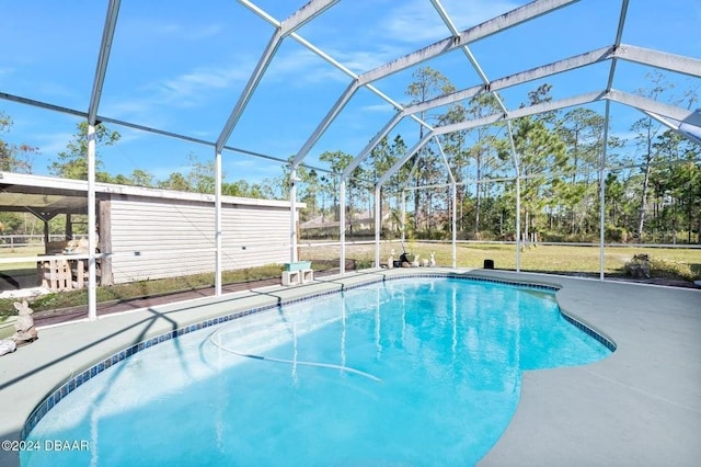 view of swimming pool featuring a patio and a lanai