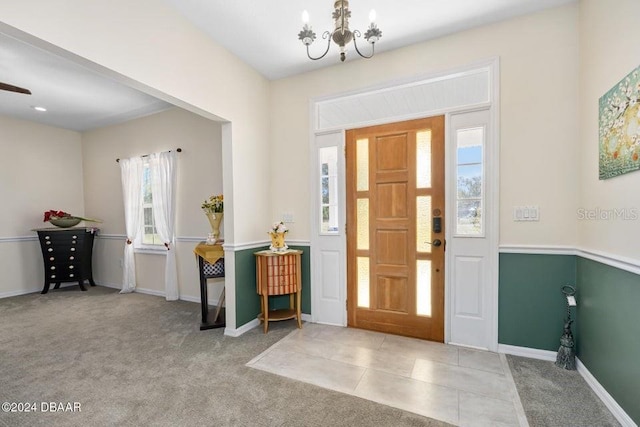 carpeted entrance foyer with a chandelier