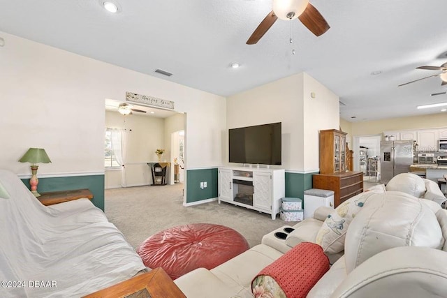 carpeted living room featuring ceiling fan