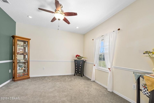 carpeted spare room with ceiling fan