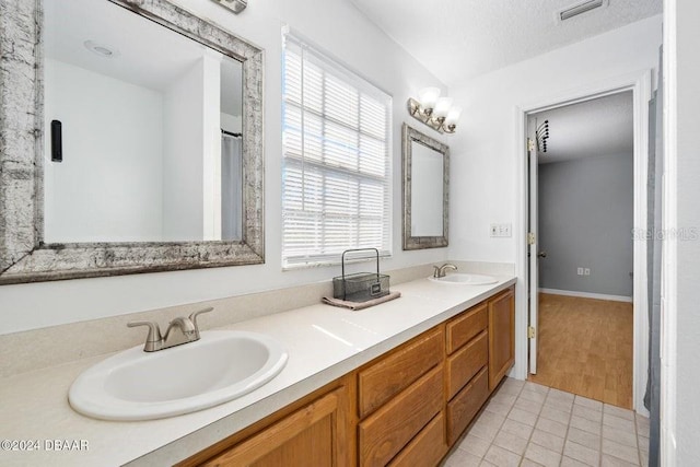 bathroom with vanity, tile patterned floors, and a textured ceiling