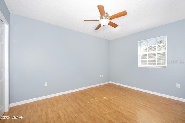 unfurnished room featuring a textured ceiling, light hardwood / wood-style flooring, and ceiling fan