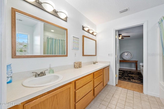 bathroom featuring tile patterned flooring, vanity, and a textured ceiling