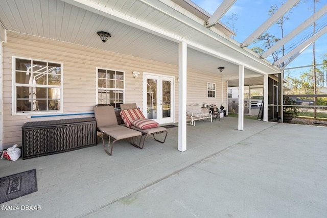 view of patio featuring glass enclosure and french doors