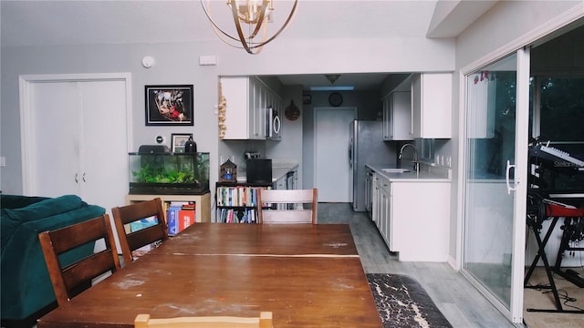 dining space featuring a notable chandelier, wood-type flooring, and sink