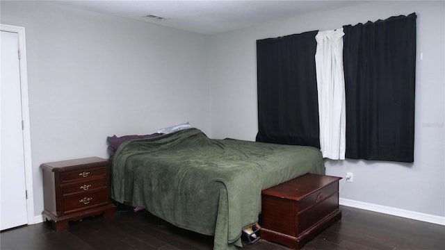 bedroom with dark hardwood / wood-style flooring