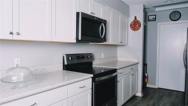 kitchen featuring white cabinets, stainless steel appliances, and light stone counters