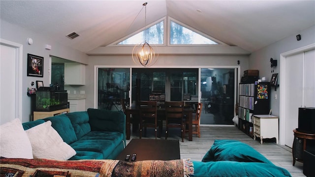 living room featuring wood-type flooring, lofted ceiling, and a chandelier