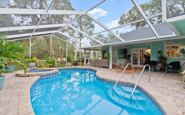 view of pool with glass enclosure, ceiling fan, an in ground hot tub, and a patio