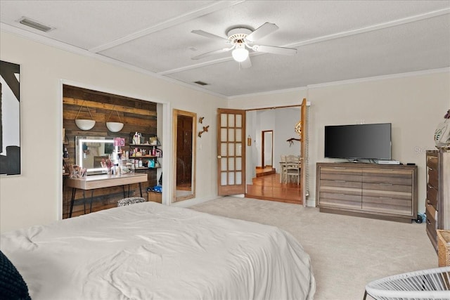 carpeted bedroom with a textured ceiling, ceiling fan, and crown molding