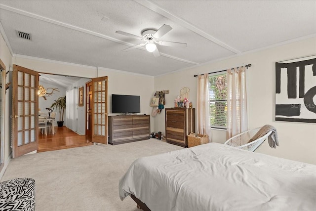 carpeted bedroom featuring french doors, ceiling fan, crown molding, and a textured ceiling