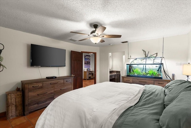 bedroom featuring tile patterned flooring, ceiling fan, a textured ceiling, and connected bathroom