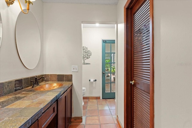 bathroom featuring tile patterned floors, vanity, and toilet