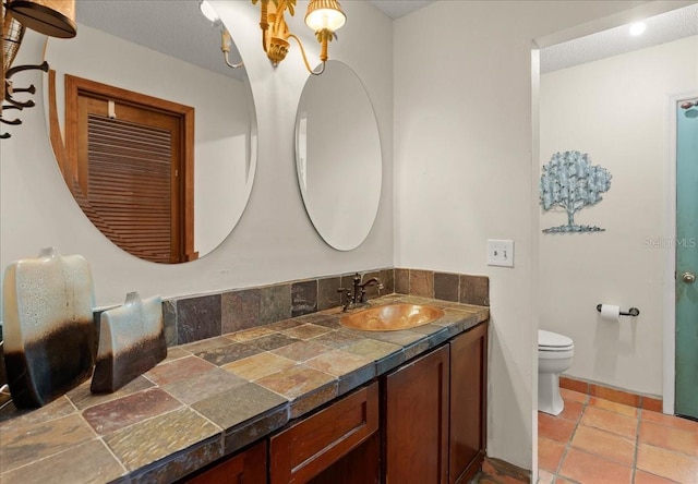 bathroom featuring vanity, toilet, and a textured ceiling