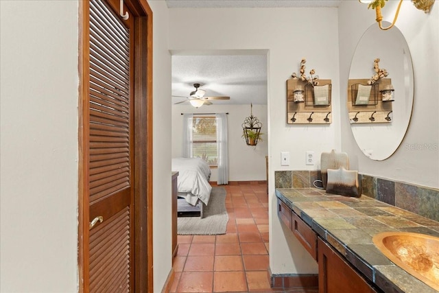 bathroom featuring tile patterned floors, vanity, ceiling fan, and a textured ceiling