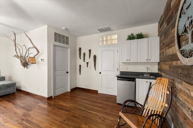 kitchen with stainless steel dishwasher, dark hardwood / wood-style flooring, white cabinets, and sink