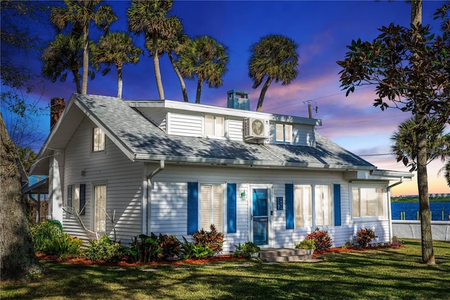 view of front of property with a yard and ac unit