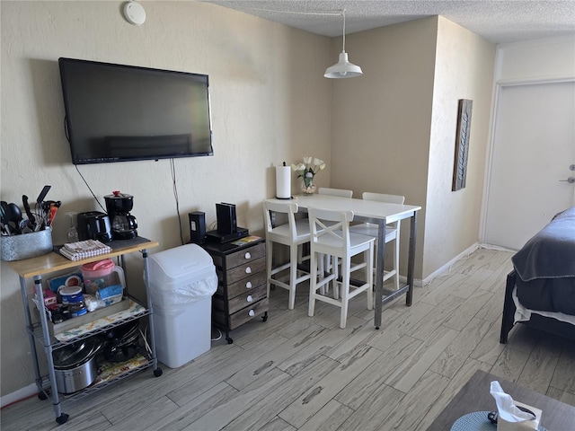 living room with light hardwood / wood-style floors and a textured ceiling