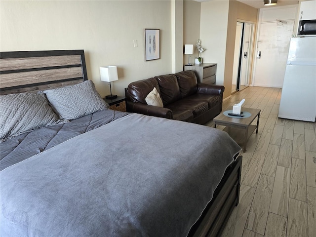 bedroom featuring a closet, light hardwood / wood-style floors, and white refrigerator