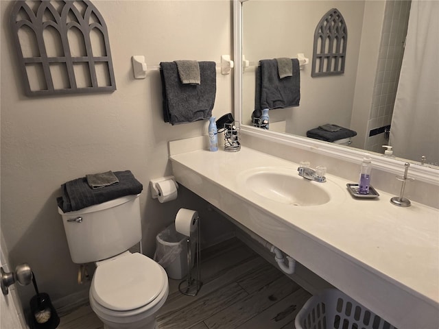 bathroom featuring hardwood / wood-style flooring, toilet, and sink