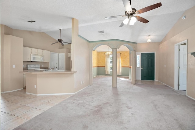 unfurnished living room with light carpet, a textured ceiling, ceiling fan, and lofted ceiling