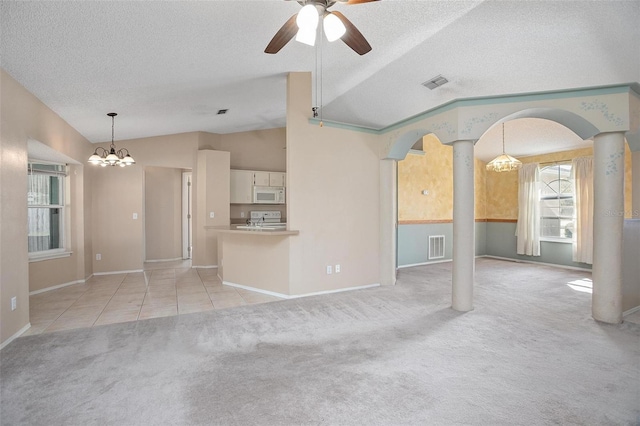 unfurnished living room featuring ceiling fan with notable chandelier, light colored carpet, lofted ceiling, and a textured ceiling