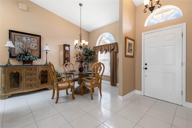 tiled entrance foyer featuring a chandelier, high vaulted ceiling, and plenty of natural light