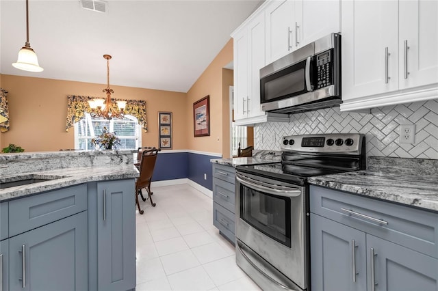 kitchen with white cabinetry, pendant lighting, a chandelier, decorative backsplash, and appliances with stainless steel finishes