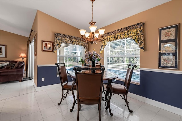 tiled dining space featuring plenty of natural light, an inviting chandelier, and vaulted ceiling