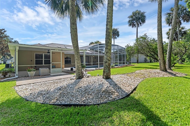 view of yard featuring glass enclosure and ceiling fan