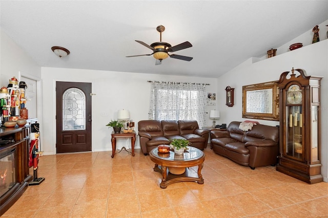 living room featuring ceiling fan, light tile patterned floors, and lofted ceiling