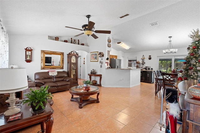 tiled living room featuring a textured ceiling, ceiling fan with notable chandelier, and lofted ceiling