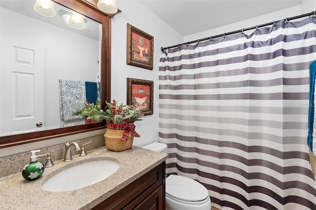 bathroom with a shower with shower curtain, vanity, and toilet