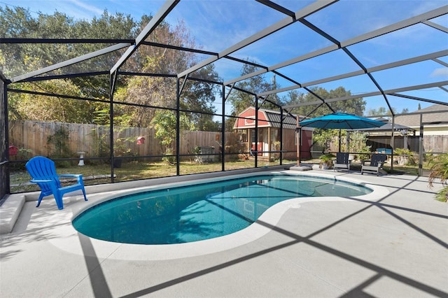 view of pool with a lanai, a patio, and a storage shed