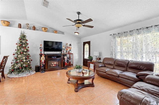 tiled living room with a textured ceiling, ceiling fan, and vaulted ceiling