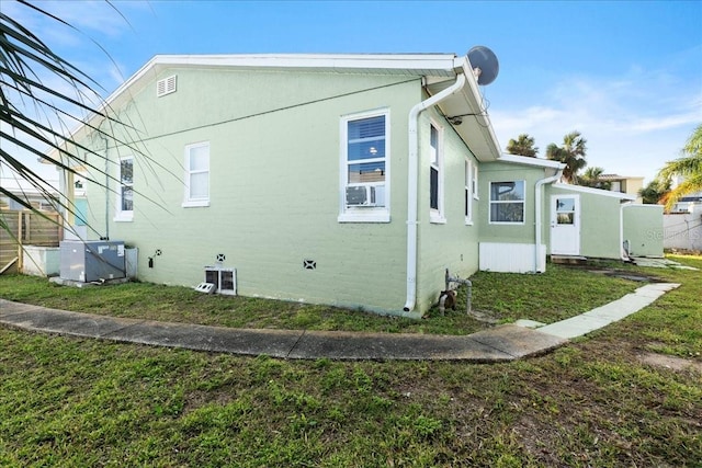 view of property exterior with central AC unit, cooling unit, and a yard