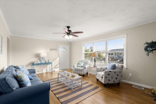 living room with wood-type flooring, ceiling fan, and ornamental molding