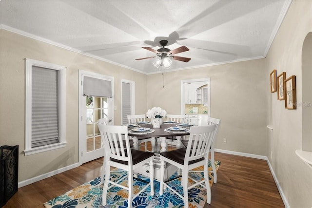 dining space featuring crown molding, ceiling fan, dark wood-type flooring, and a textured ceiling