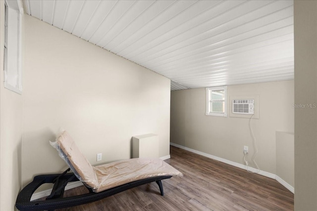 sitting room featuring a wall unit AC and wood-type flooring