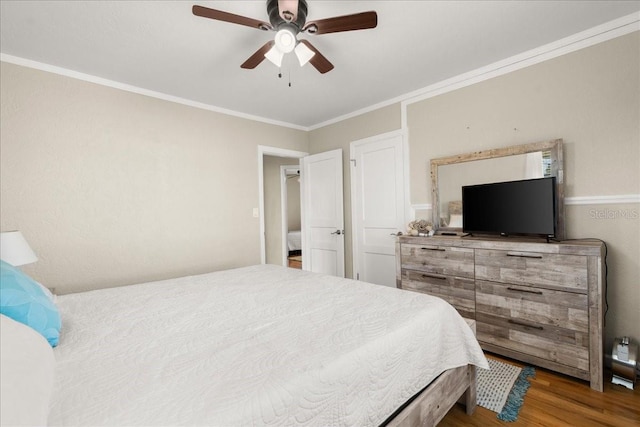 bedroom with ceiling fan, ornamental molding, and dark wood-type flooring