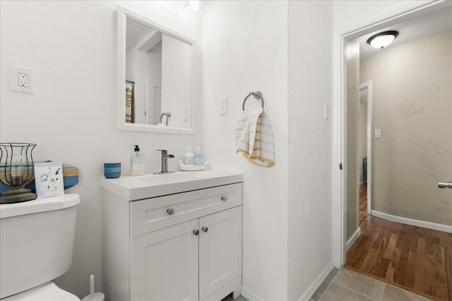 bathroom with wood-type flooring, vanity, and toilet