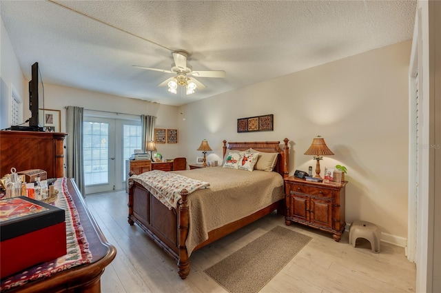 bedroom featuring a textured ceiling, french doors, access to exterior, light wood-type flooring, and ceiling fan