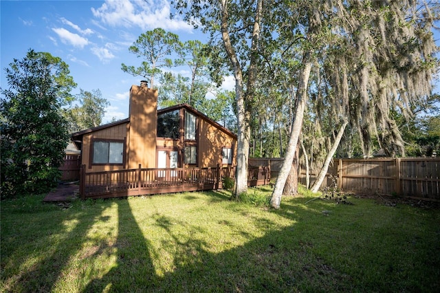 back of house featuring a lawn and a deck