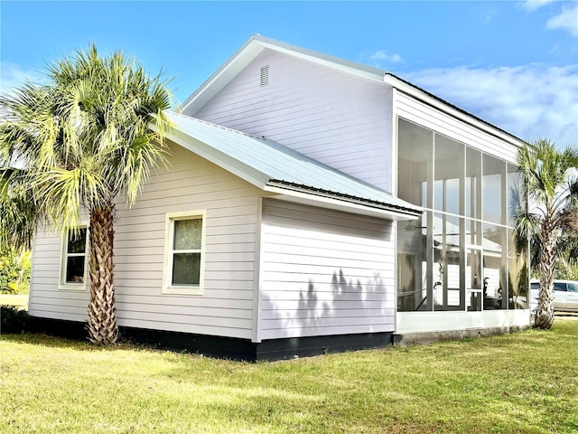 view of property exterior featuring a lawn and a sunroom