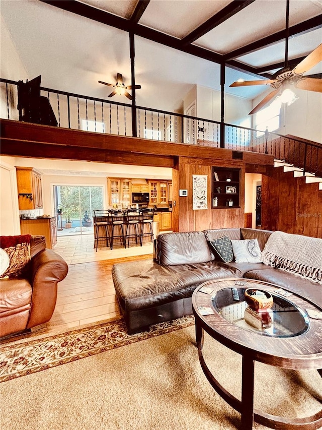 living room featuring beamed ceiling, hardwood / wood-style floors, a towering ceiling, and coffered ceiling