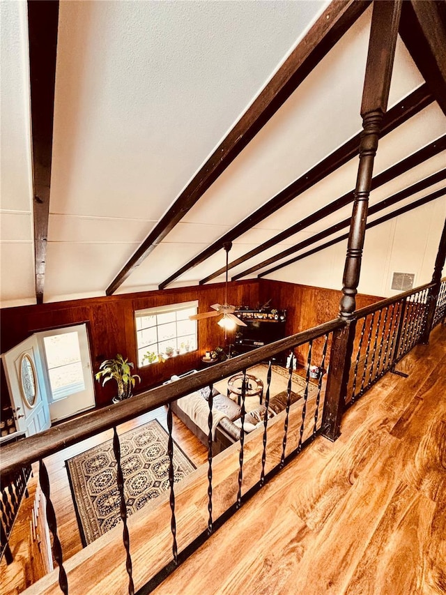 corridor featuring hardwood / wood-style floors, vaulted ceiling with beams, and wood walls