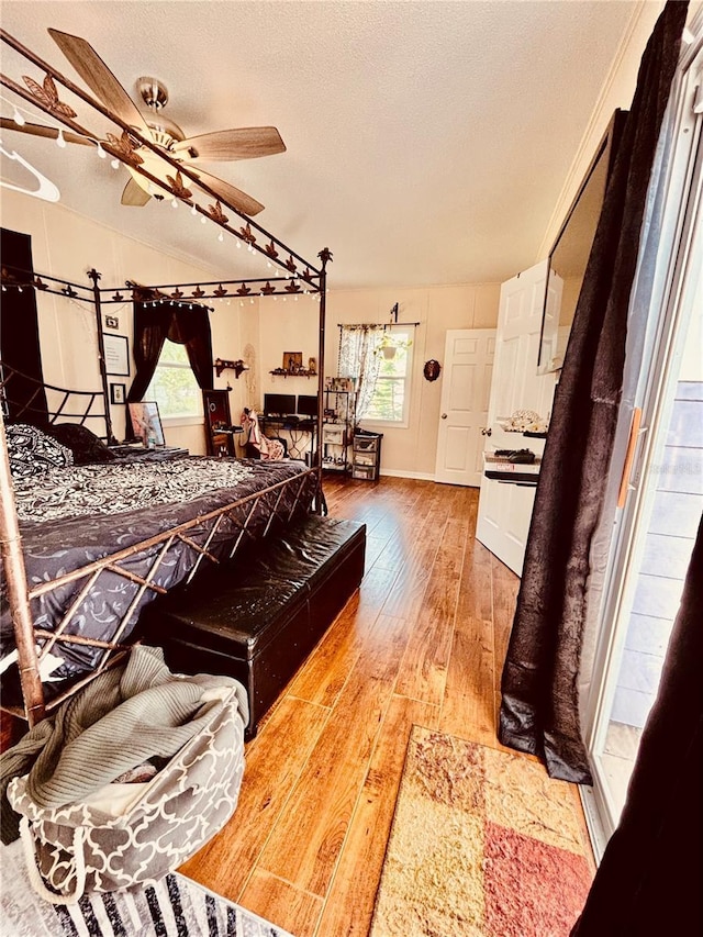 bedroom featuring hardwood / wood-style floors, a textured ceiling, and ceiling fan