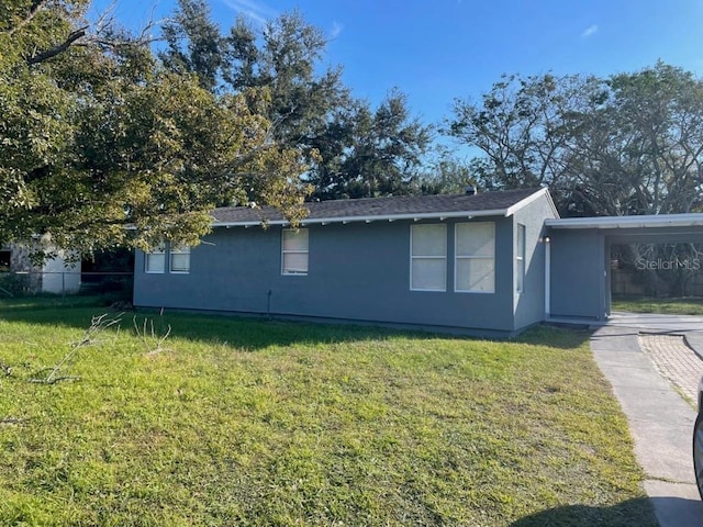 view of side of property with a yard and a carport